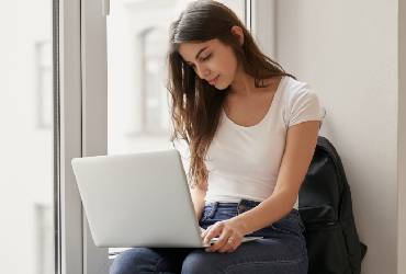 Home Two httpselements.envato.compretty girl sitting on windowsill with laptop in u hvnw9mz 1.jpg